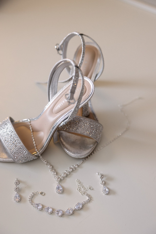 Silver heels and sparkling jewelry arranged before Yariana’s quinceañera.