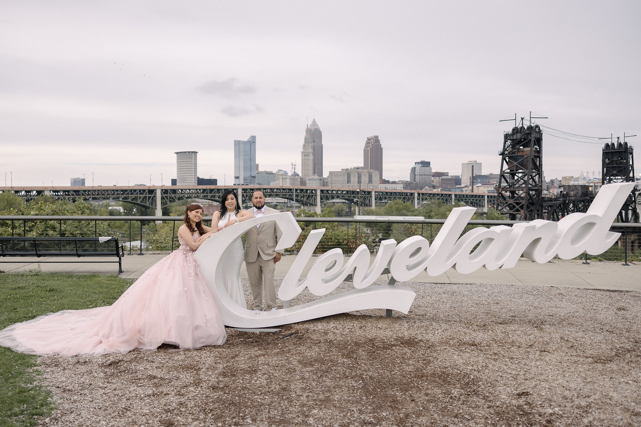 Yariana beside the Cleveland script sign with the city skyline behind her.