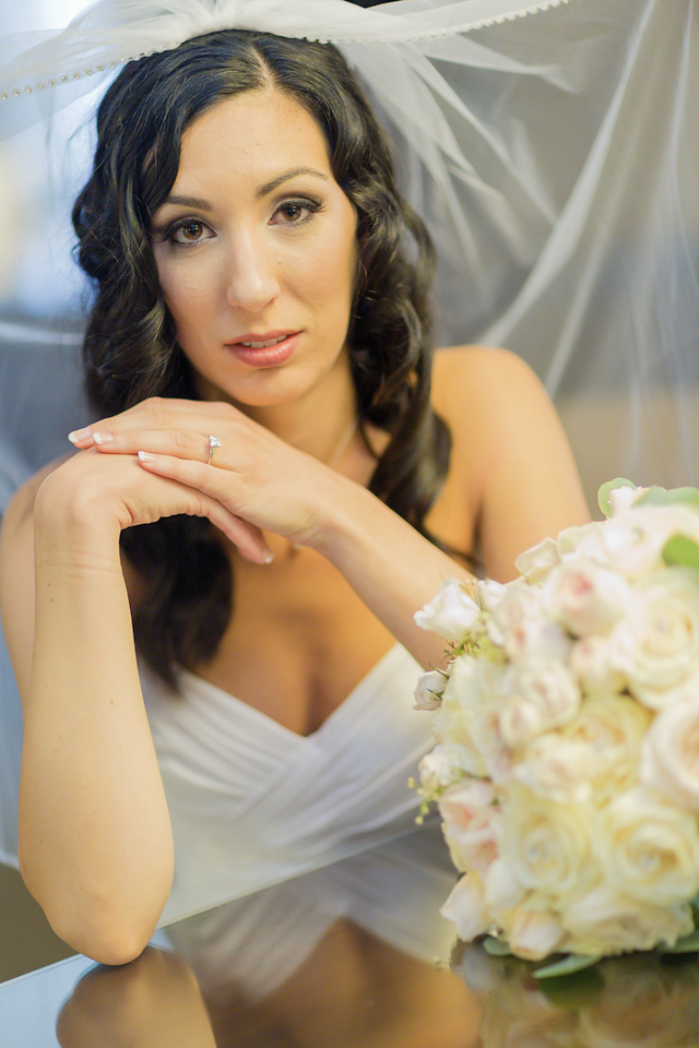 Nicole holding her bouquet beneath her veil