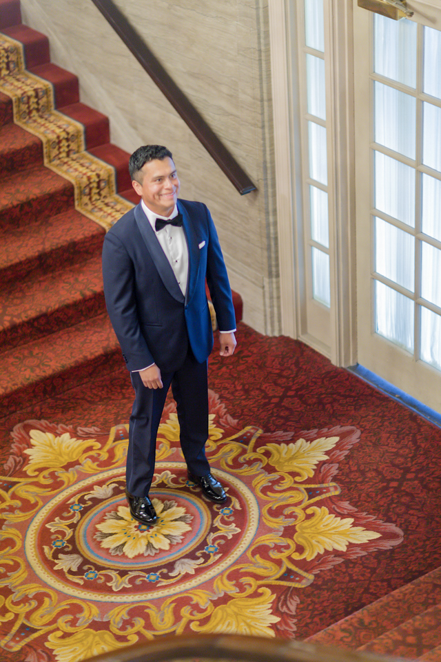 Malcolm standing at the hotel staircase