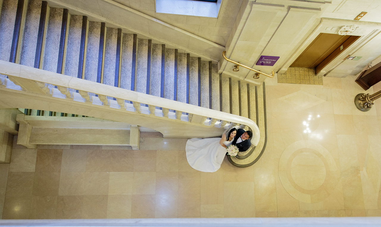 Overhead architectural portrait of the couple beside a stairway