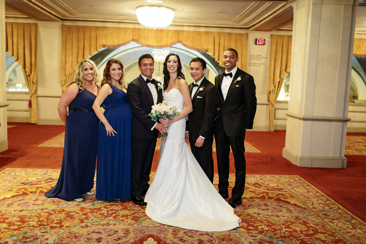 Nicole and Malcolm posing with their wedding party